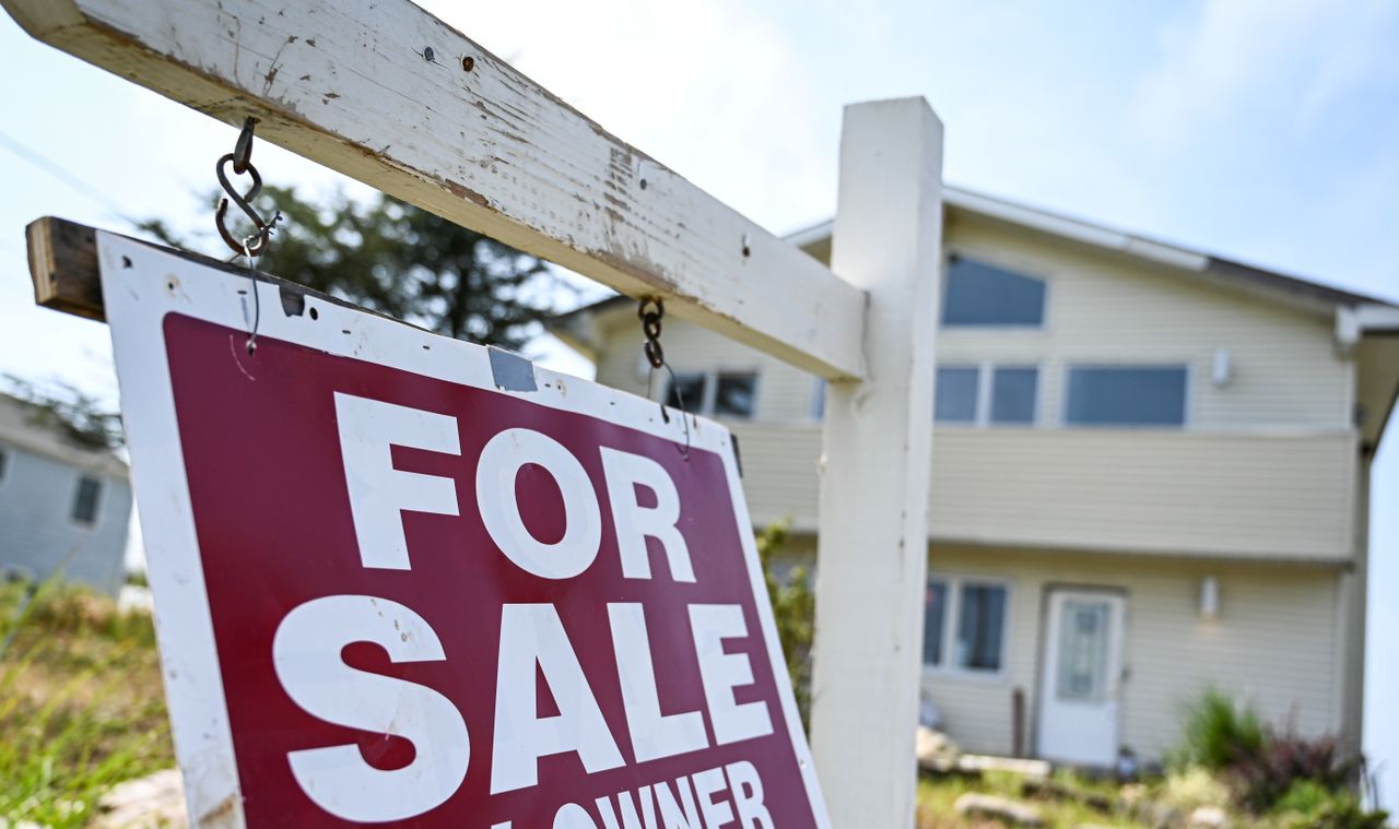 A &amp;quot;For Sale&amp;quot; sign is seen in front of a house. 