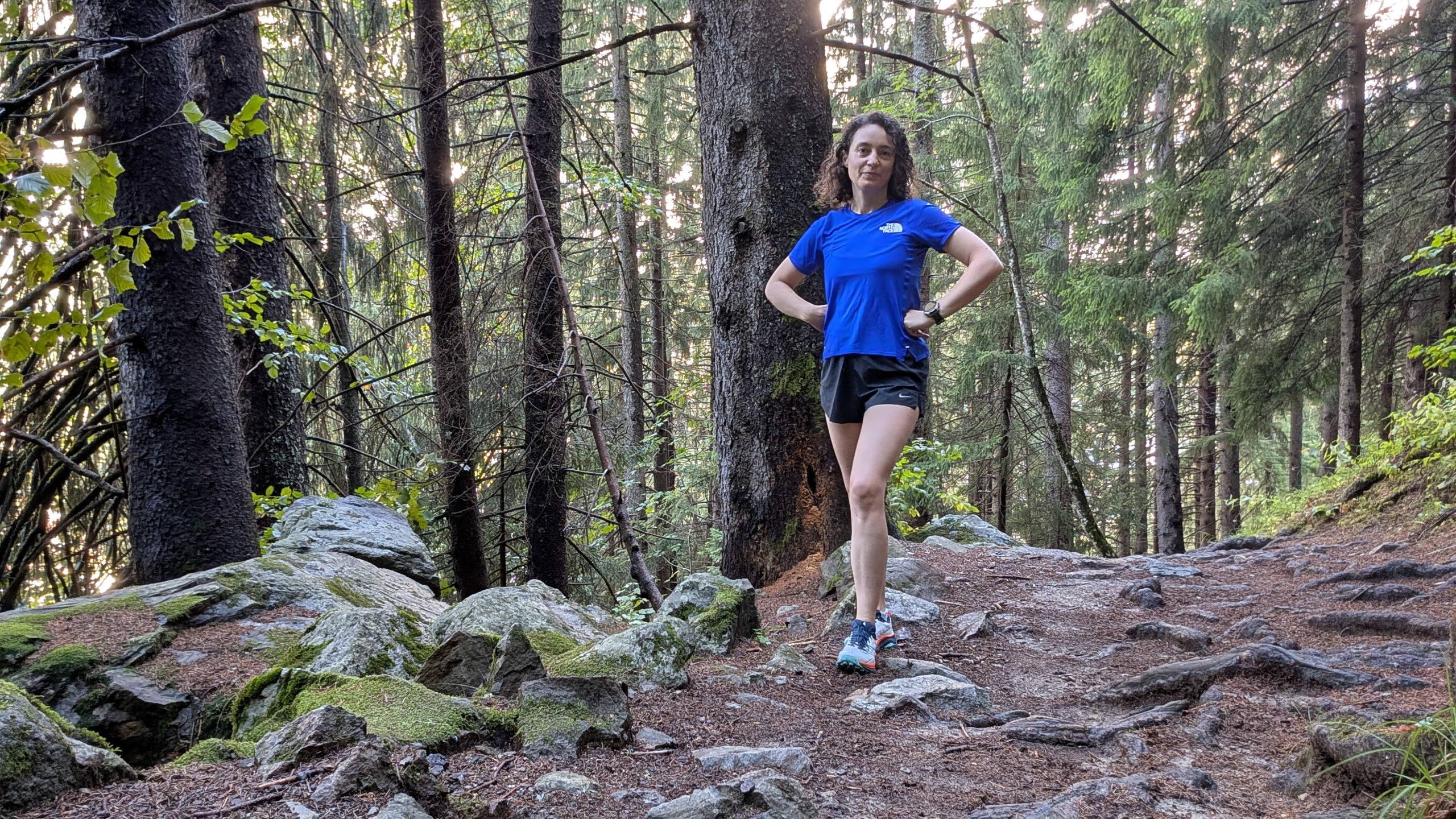A runner in the forest wearing a blue shirt and the Saucony Peregrine 16 trail shoes