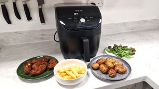 Instant Vortex Slim XL Air Fryer behind 4 plates of food