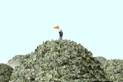 Growing savings: Man standing atop a mountain of money