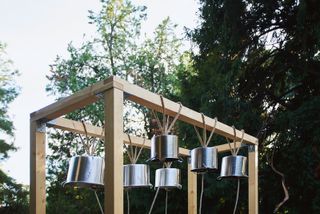 Metal pots hanging upside down on wooden structure