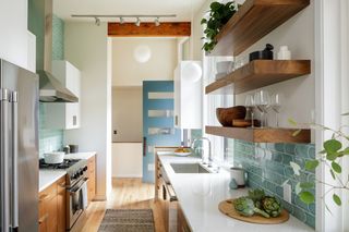 Small kitchen with wood cabinets and floor and blue backsplash