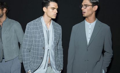 2 male models in grey clothing talking