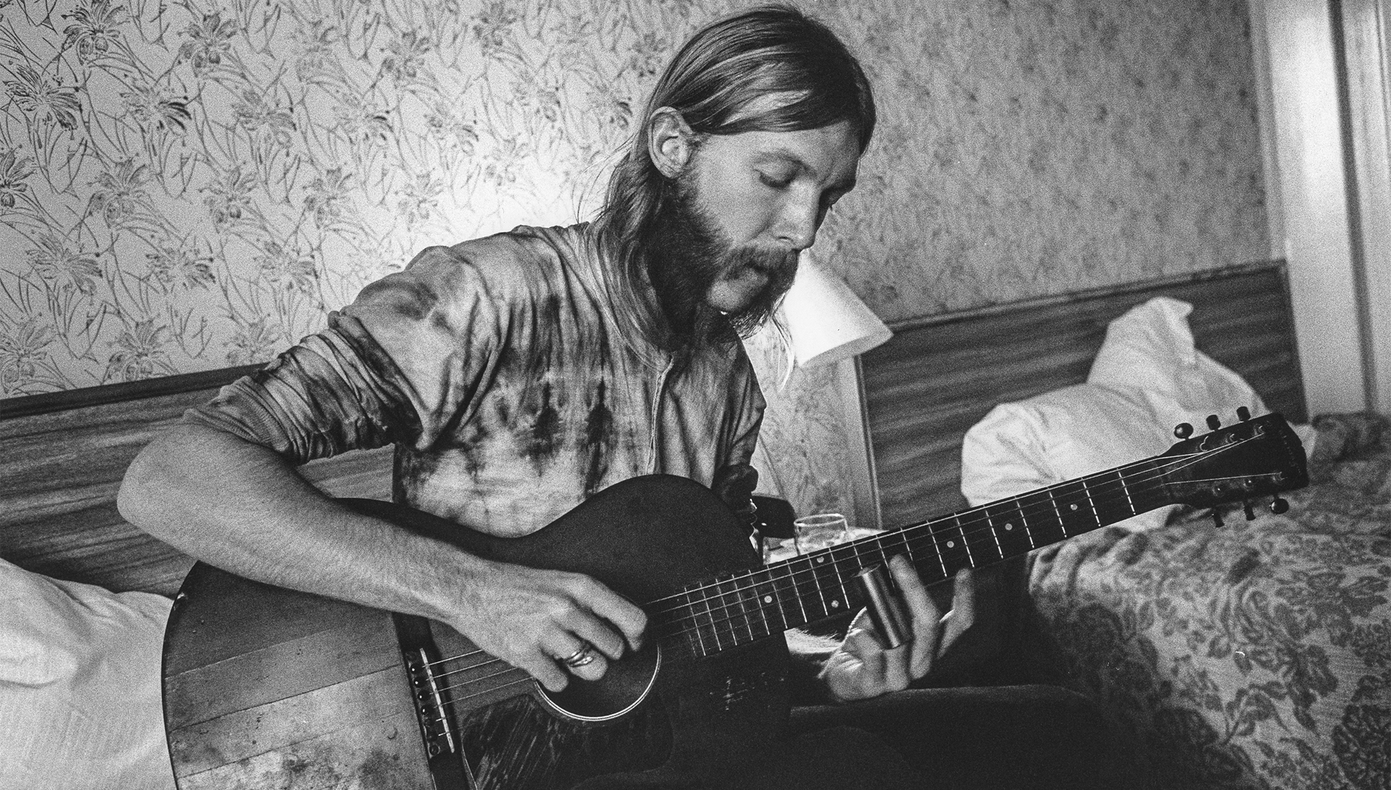 Guitarist Duane Allman uses a steel slide on an acoustic guitar in his hotel room before the Allman Brothers' performance at the Sitar on October 17, 1970 in Spartanburg, South Carolina.