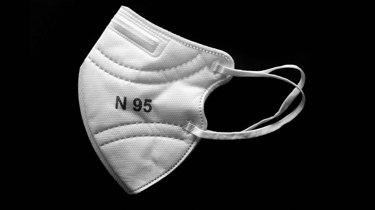 An N95 medical grade mask against a black background