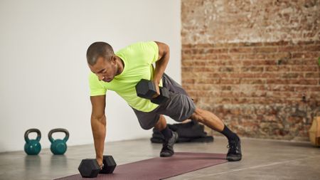 Man performing dumbbell renegade rows