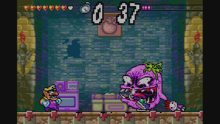 Wario Land 4 screenshot showing Wario facing down a purple enemy
