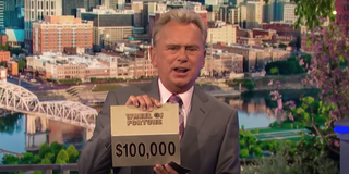 pat sajak holding up $100,000 prize card on wheel of fortune