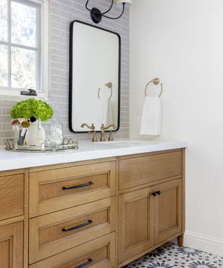 Bathroom with a wooden vanity and black hardware