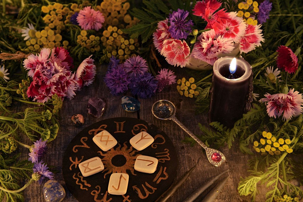 Flowers On A Table Next To A Zodiac Signs A Candle And Other Ritual Objects