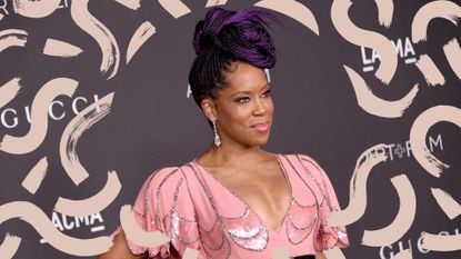 Regina King on the red carpet wearing a long braided hairstyles, long box braids in a bun