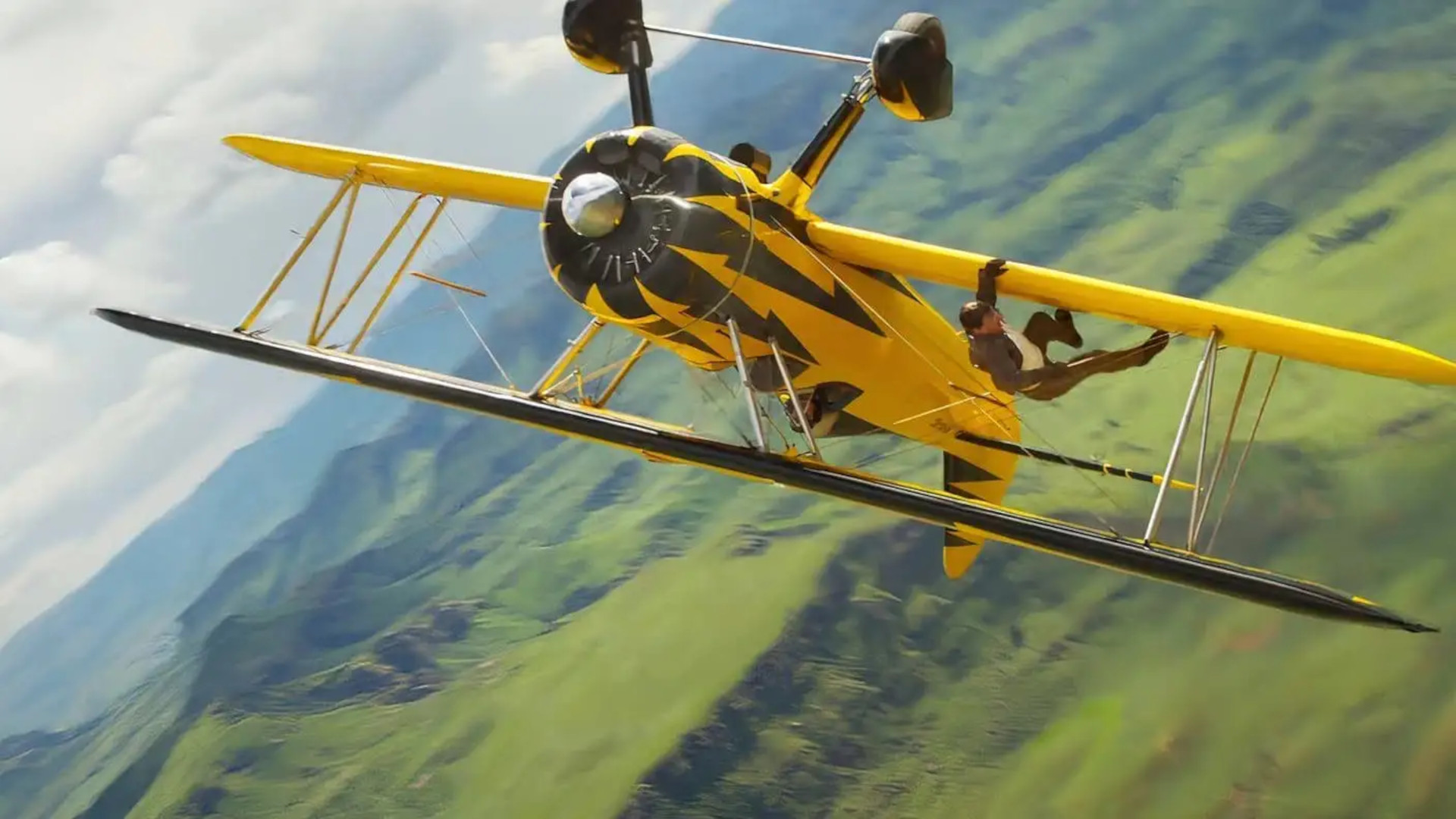Mission Impossible movies in order: Tom Cruise as Ethan Hunt grabbing the wing of a flying yellow plane during Mission Impossible The Final Reckoning.