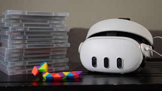 A Meta Quest 3 headset with a stack of game boxes next to it