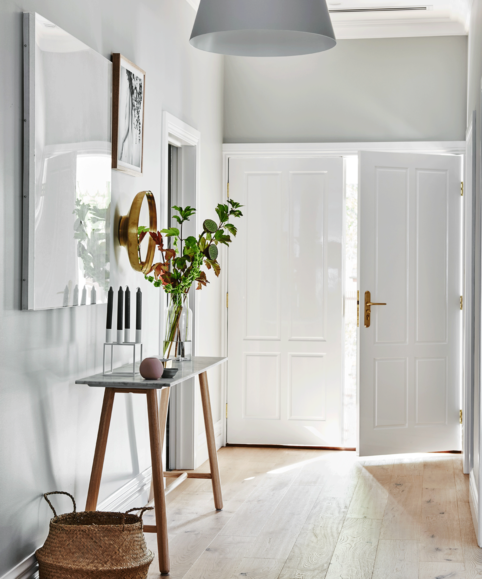 hallway with side table with vase of foliage