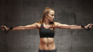 Benefits of resistance bands: image shows woman stretching resistance band