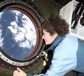 Astronaut Susan J. Helms, Expedition Two flight engineer, views the topography of a point on Earth from the nadir window in the U.S. Laboratory Destiny module of the International Space Station
