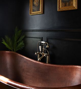 Black bathroom with copper bath