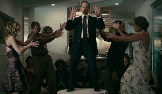 The Perfect Host David Hyde Pierce dances on top of a table, surrounded by friends