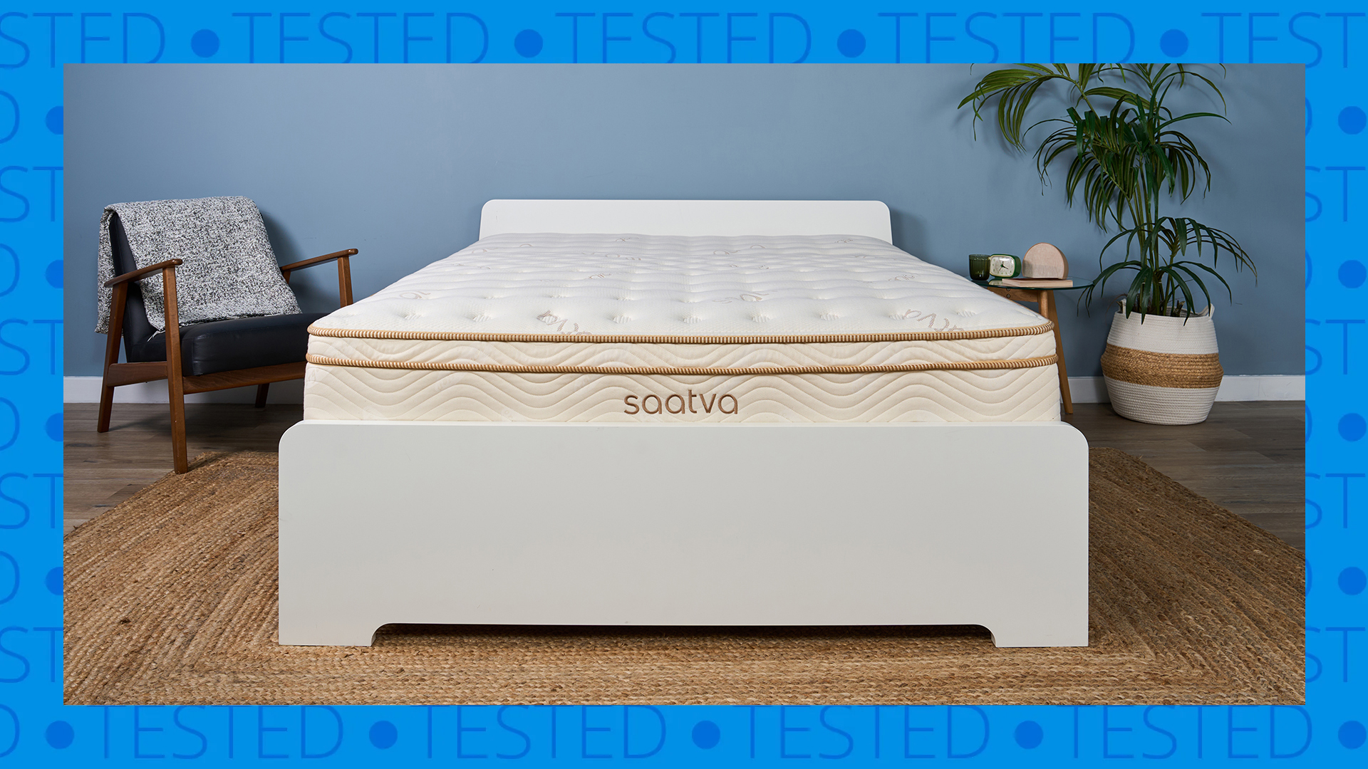 A Saatva Classic mattress on a bed frame in our Sleep Lab. A blue background with the word 'tested' surrounds it