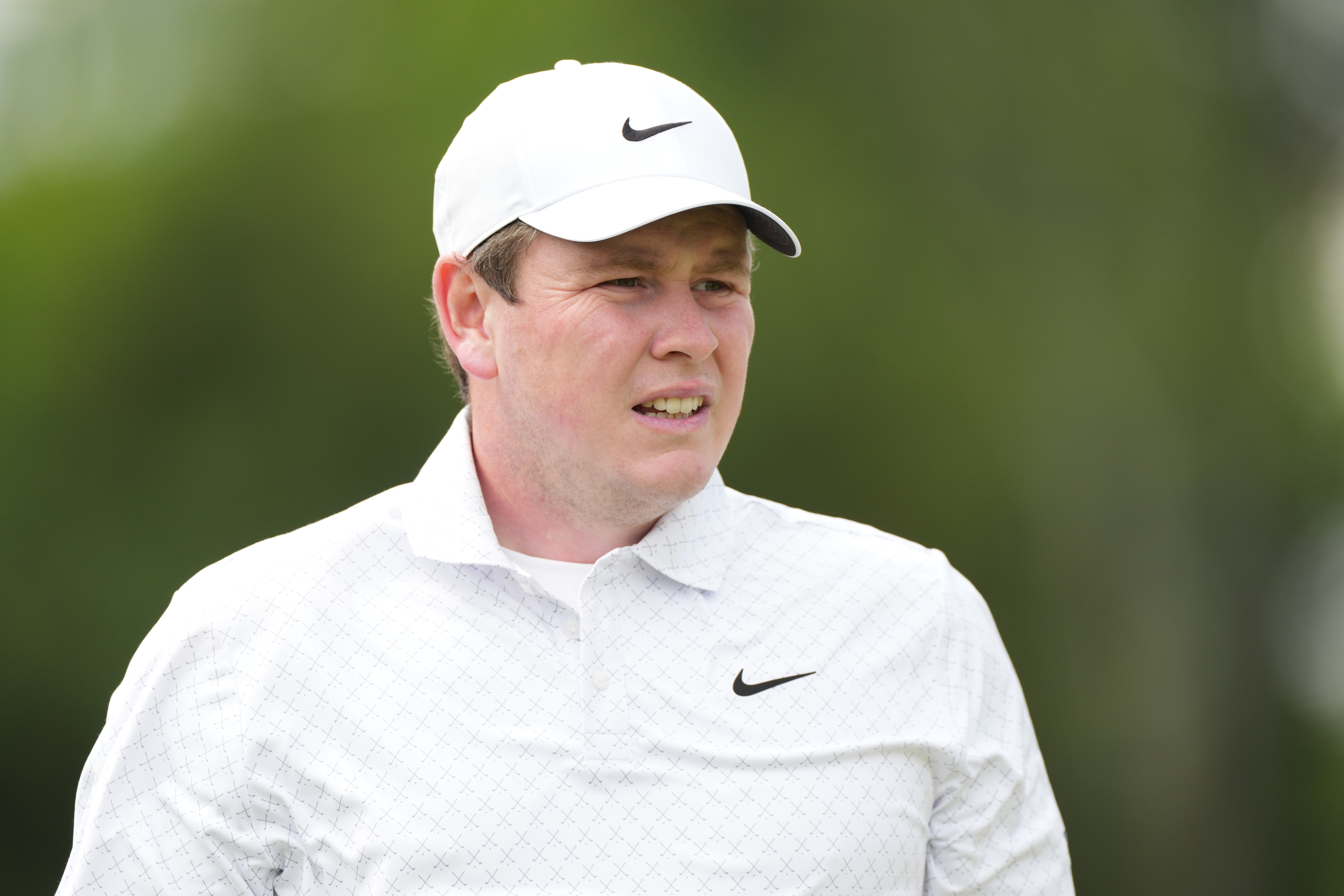 Robert MacIntyre wearing a white Nike polo and white Nike cap from the chest up