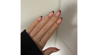 A close-up picture of Digital Beauty Writer, Sennen Prickett's burgundy French tip nails