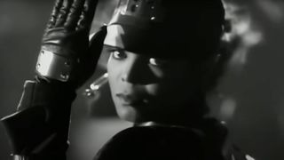 Janet Jackson looks directly into the camera in the 1989 Rhythm Nation music video.