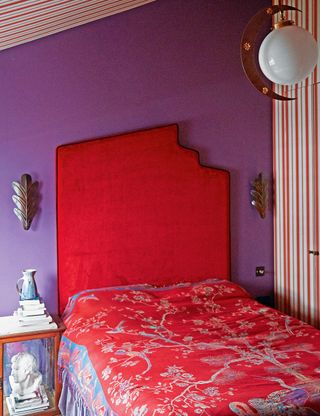 Purple bedroom with bright red headboard and red patterned bedding