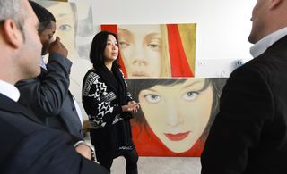 An Xiaotong explains the thought behind her artwork series, inspired by social networks, during the private tour of her Paris studio