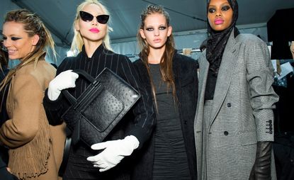 Model holds up a black leather bag with white gloves, another wears a black teddy coat, whilst another is dressed in a checkered suit