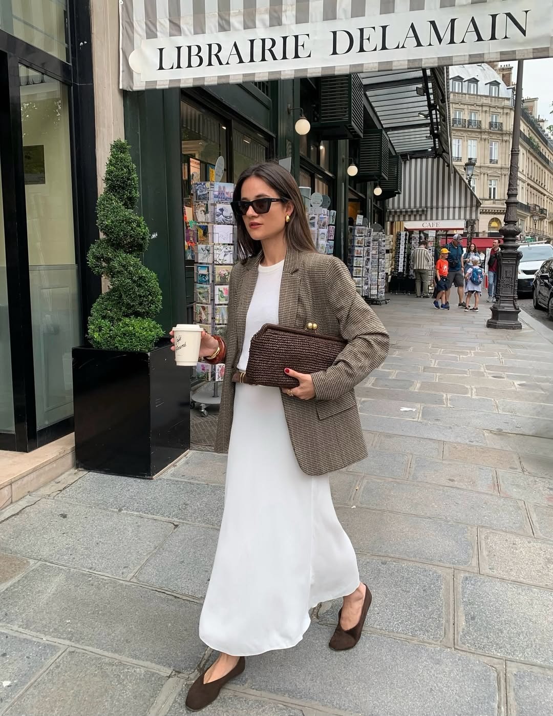 Influencer wears a white slip skirt and a tweed blazer with suede ballet flats.