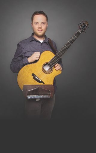 Trevor Gordon Hall holds his Kalimbatar, a steel-string guitar equipped with a custom kalimba finger piano