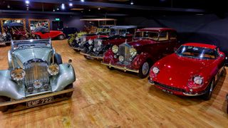 Vintage cars parked on the wooden floor of a hall
