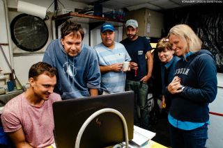 The team gathered around the computer to see the giant squid footage. From left to right: Nathan Robinson, Sonke Johnsen, Tracey Sutton, Nick Allen, Edie Widder and Megan McCall.