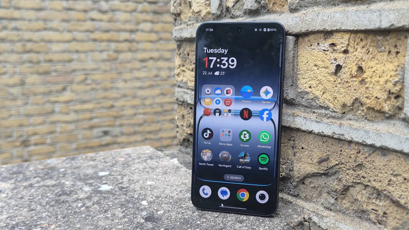 The OnePlus Nord 5 against a brick wall.