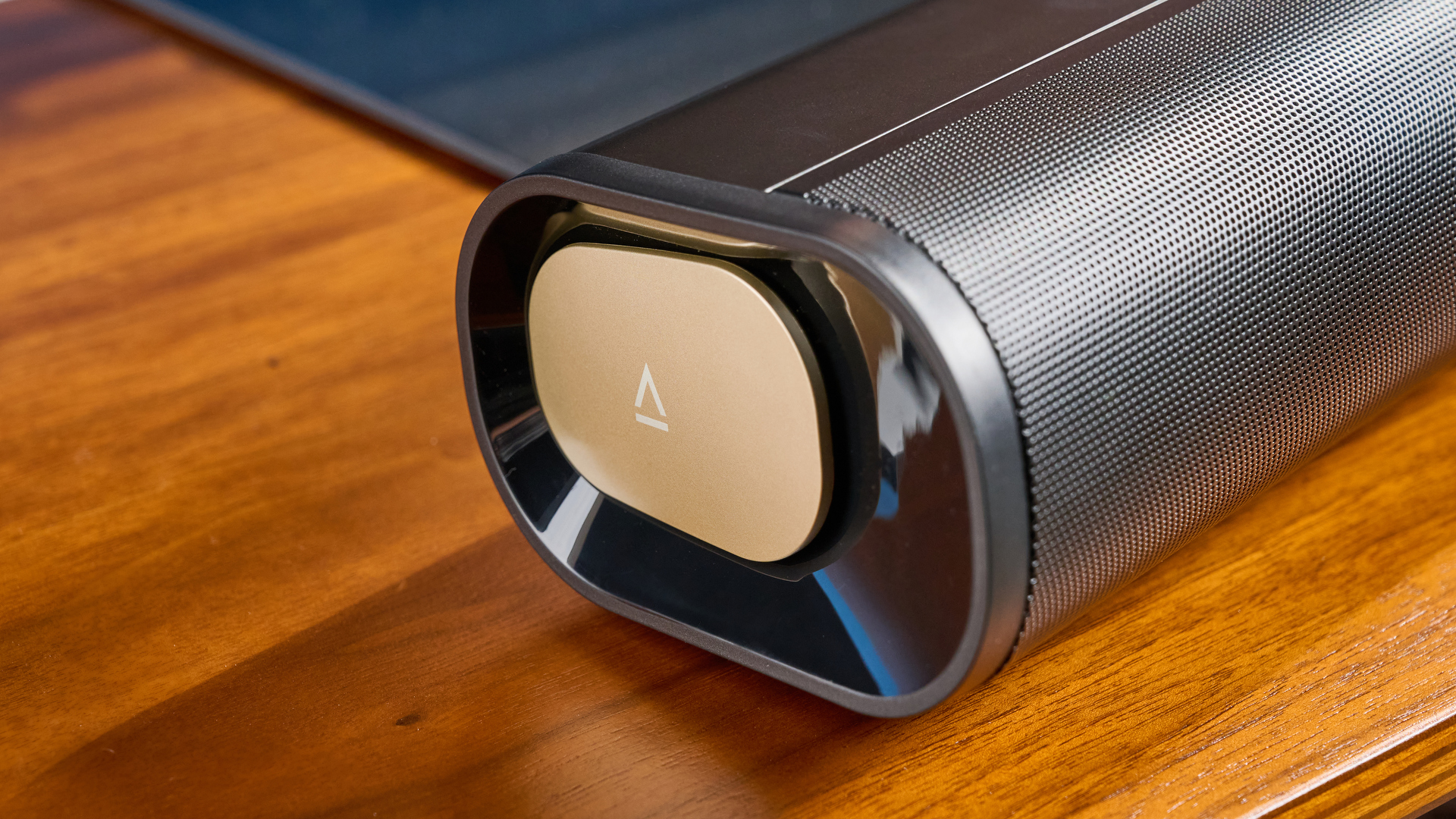 the creative stage pro soundbar and subwoofer, a super-budget home cinema system with 2.1 channels and a remote control photographed on a wooden tv stand with a TV behind