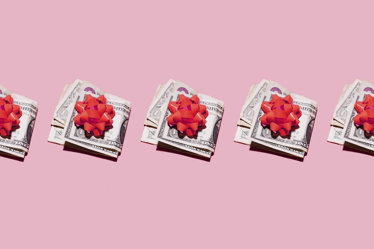 row of folded dollar bills with red gift bows