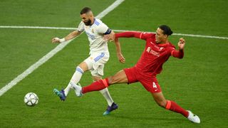 Karim Benzema of Real Madrid is challenged by Virgil van Dijk of Liverpool during a UEFA Champions League match between Liverpool FC and Real Madrid