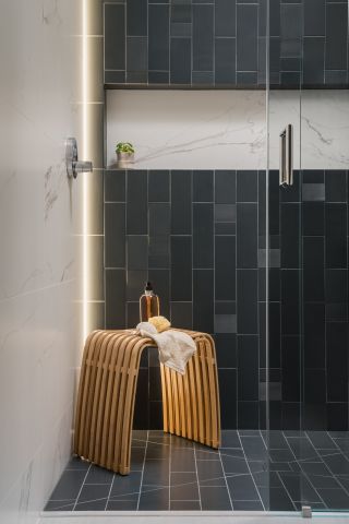 black bathroom shower with vertical subway tiles by Interiors by Popov