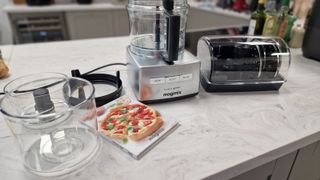 Magimix 4200XL Food Processor on a counter alongside its various attachments