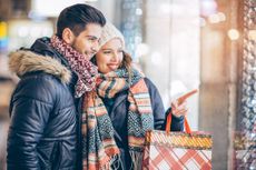 Couple in winter clothes doing some holiday shopping.