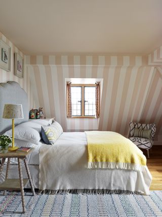 Pink and white stripped wall, grey bed head