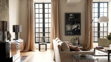 a beautiful living room with floor to ceiling windows, draped curtains, and modern furniture