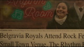 A newspaper clipping showing The Princess Switch's Princess Stacy (Vanessa Hudgens) standing in front of the neon Rhythm room sign