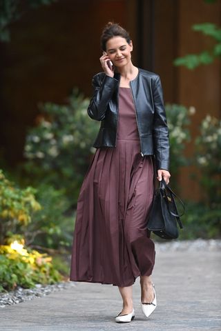 Katie Holmes walks in manhattan wearing a burgundy dress and a collarless leather jacket