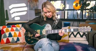 Arianna Powell of Pickup Music with a green Gretsch guitar