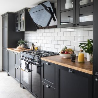Kitchen with black cabinetry and white metro tiled splashback