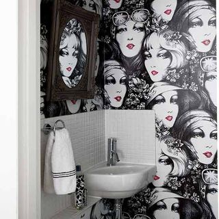 bathroom with portrait printed wall and white washbasin
