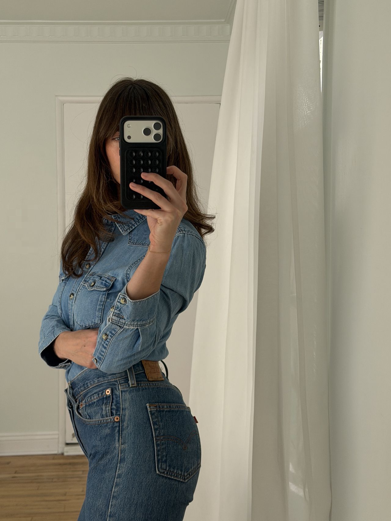 Kathryn Zahorak posing in mirror wearing denim shirt and jeans and leopard print heels