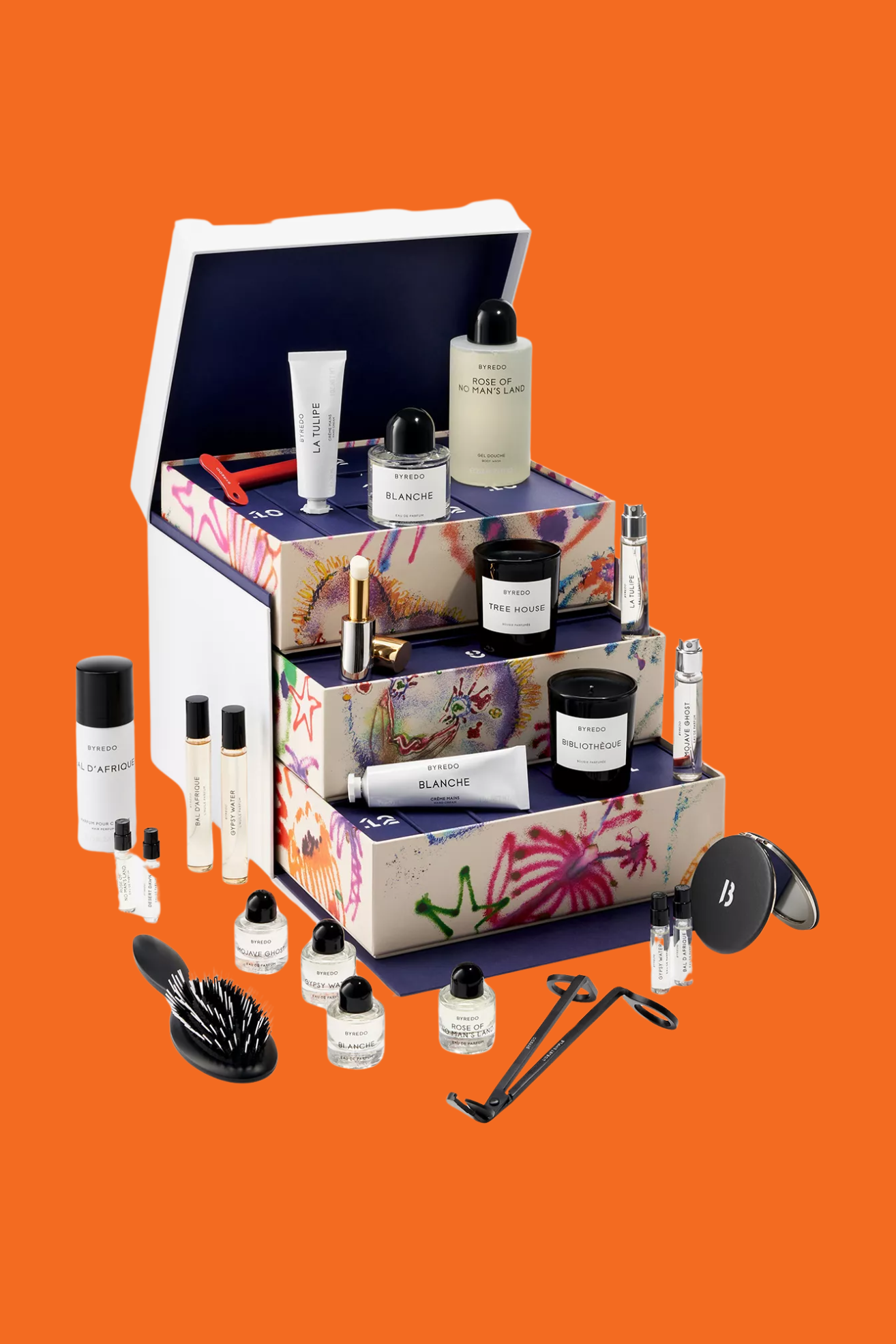 A white tiered advent calendar with candles, eau de parfums, a wick snipper, a brush and more