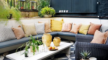 Seating area in the garden surrounded by trees and flowerbeds with white and green hydrangeas